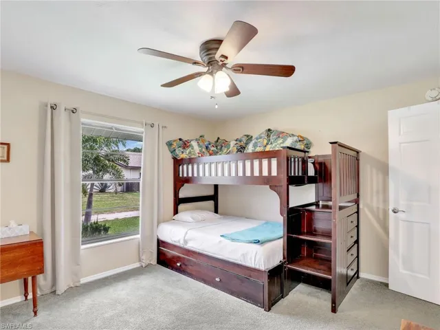 Carpeted bedroom featuring ceiling fan