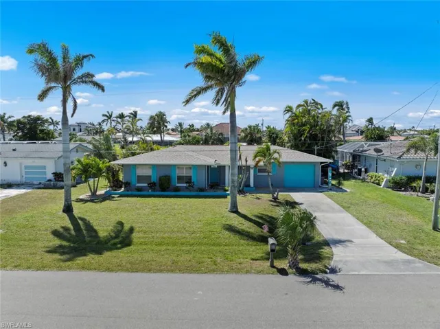 Single story home featuring driveway, a garage, and a front yard