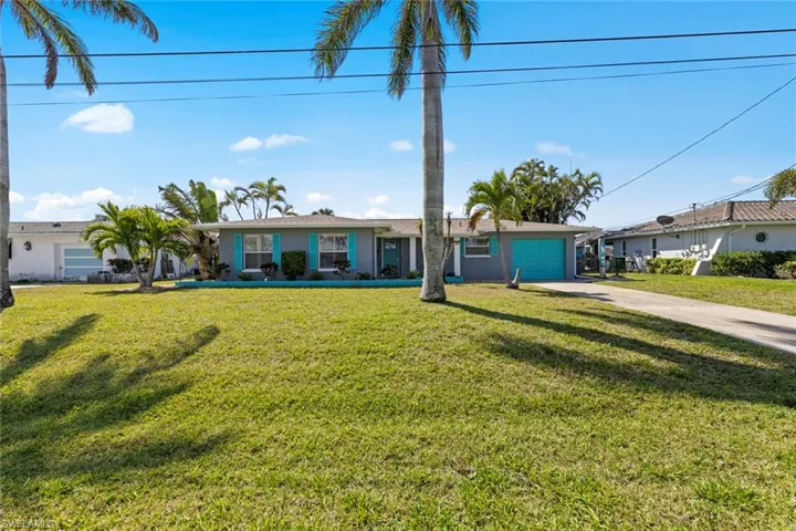Single story home with a front yard, stucco siding, an attached garage, and concrete driveway
