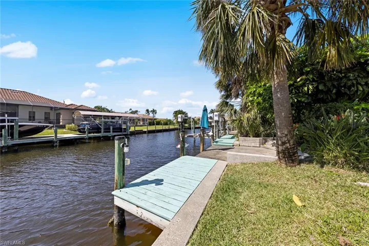 View of dock featuring a lawn, a water view, and boat lift