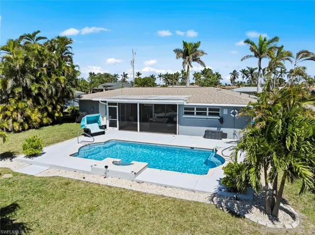 Pool featuring a lawn, a sunroom, and a patio area