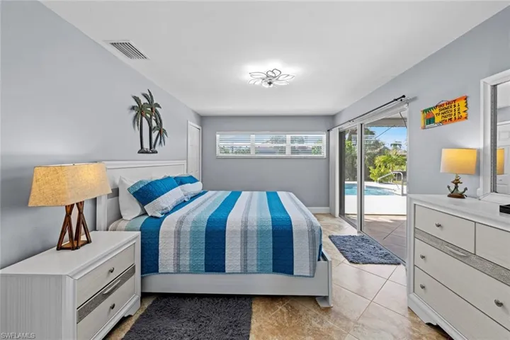 Bedroom with access to outside and light tile patterned floors