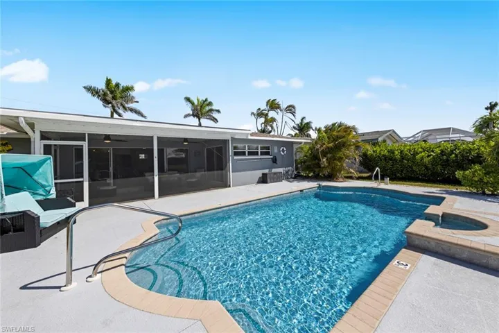 Outdoor pool featuring a screened patio area