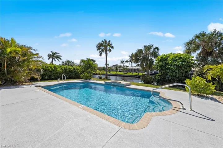 View of swimming pool with a water view, a pool and a patio area