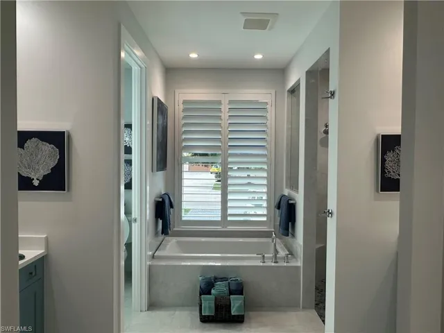 Bathroom featuring vanity and shower with separate bathtub