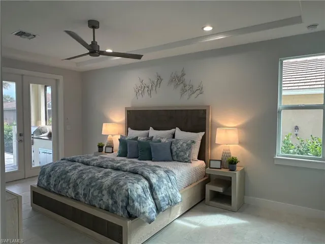 Bedroom with access to outside, ceiling fan, and multiple windows