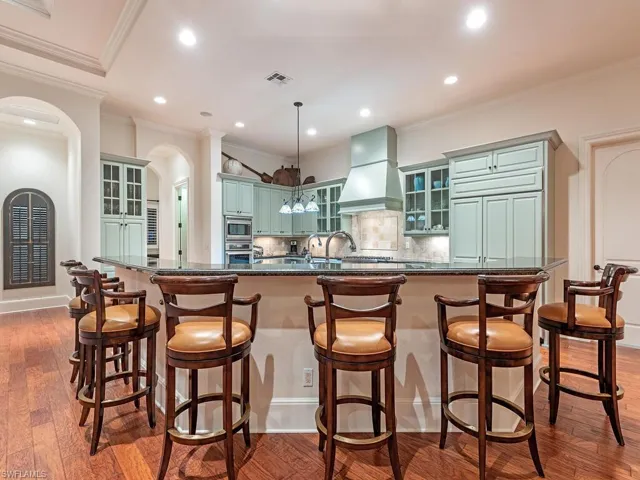 Kitchen with glass insert cabinets, decorative backsplash, ornamental molding, dark wood-style flooring, and recessed lighting