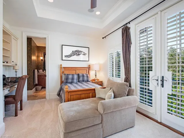 Bedroom featuring ornamental molding, access to outside, a raised ceiling, ceiling fan, and light carpet