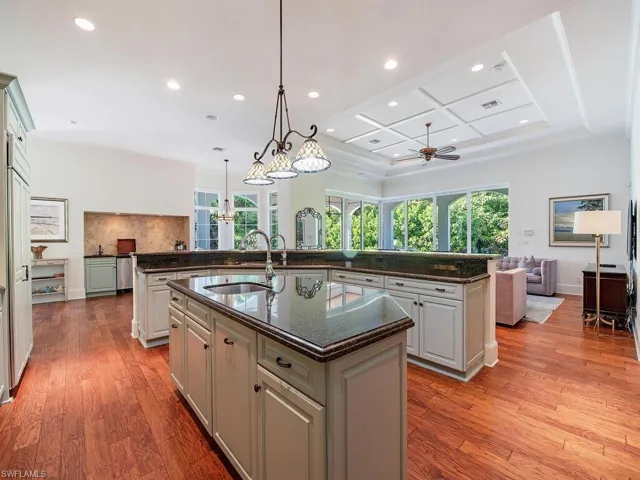 Kitchen featuring open floor plan, dark stone counters, recessed lighting, pendant lighting, and light wood-type flooring