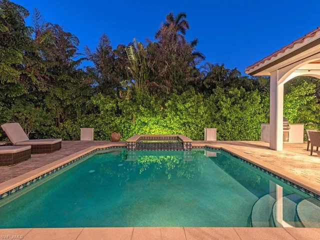 View of pool with a patio area and a pool with connected hot tub