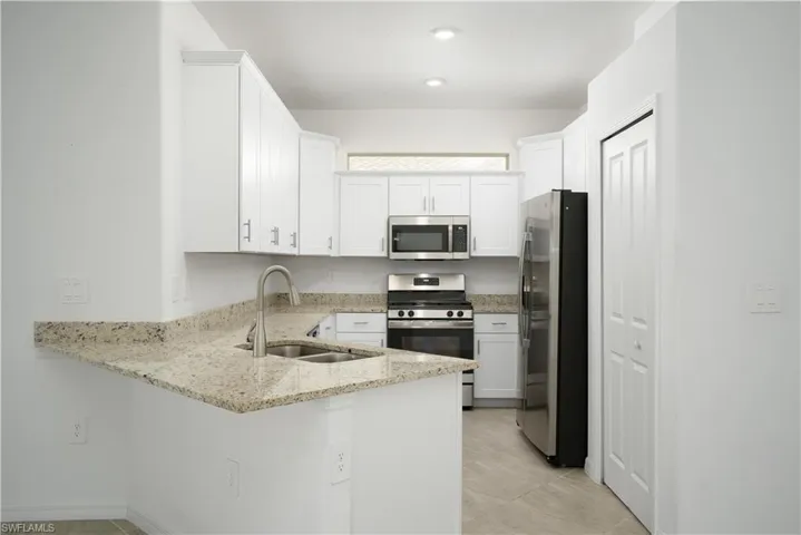 Light bright and airy kitchen with transom window above the cabinets allowing for additional natural light in the kitchen