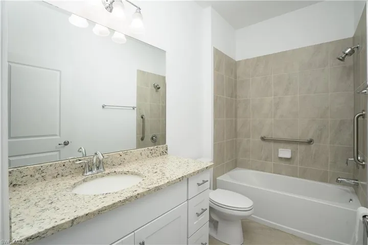 Guest bathroom with tiled tub/shower.