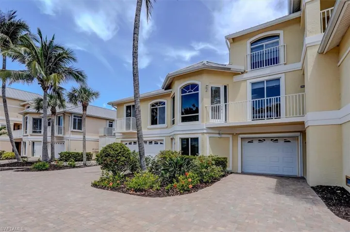 View of front of property with a garage, stucco siding, and decorative driveway