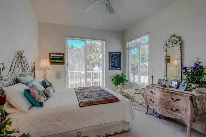 Carpeted bedroom with a ceiling fan and access to outside