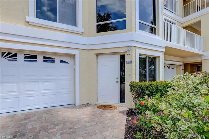 Entrance to property with an attached garage and stucco siding