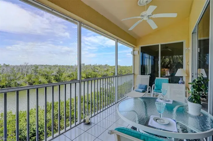 Sunroom/ Lanai with a water view, outdoor dining space, and ceiling fan