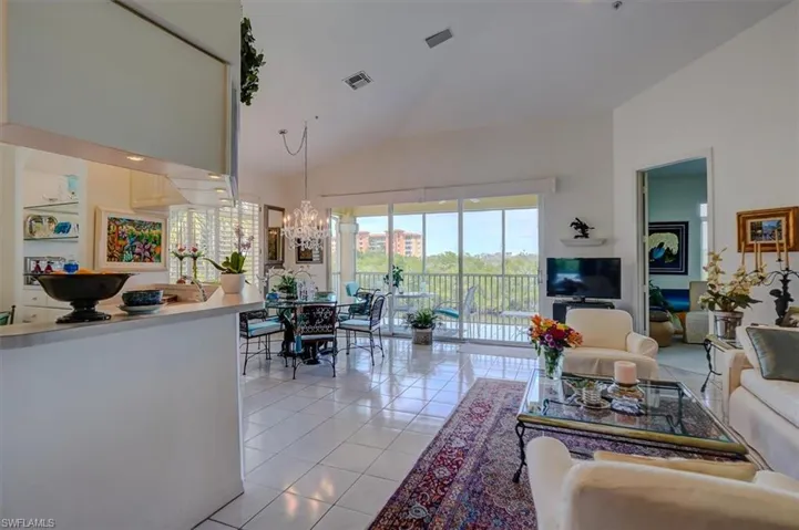 Living area featuring an inviting chandelier, high vaulted ceiling, and light tile patterned floors