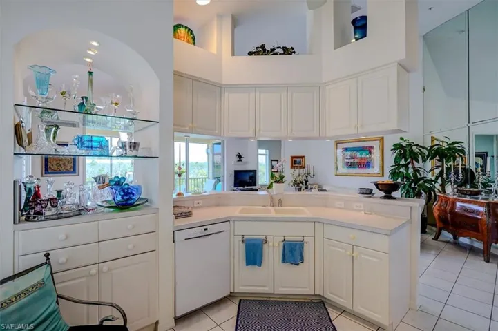 Kitchen with light countertops, dishwasher, a sink, light tile patterned flooring