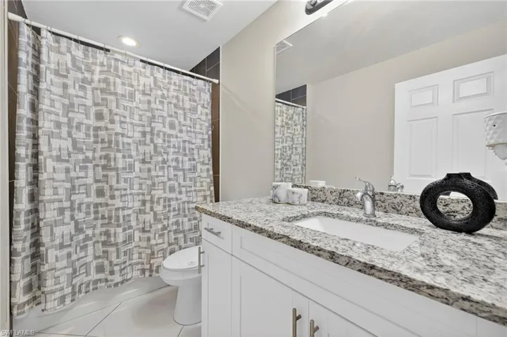 Bathroom featuring vanity, light tile patterned flooring, recessed lighting, and a shower with curtain
