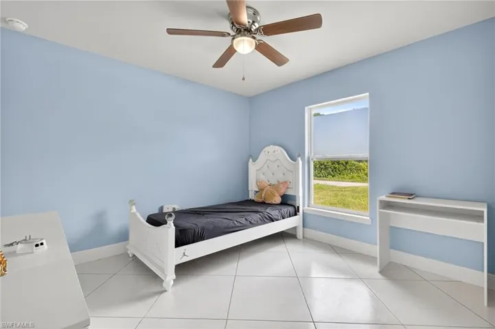 Bedroom featuring light tile patterned floors and ceiling fan