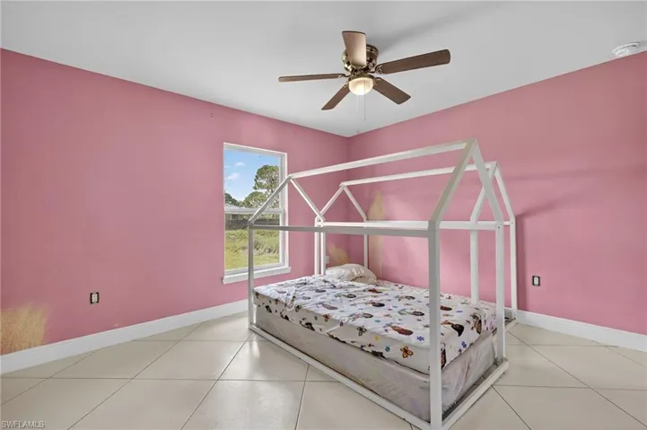 Bedroom with light tile patterned flooring and ceiling fan