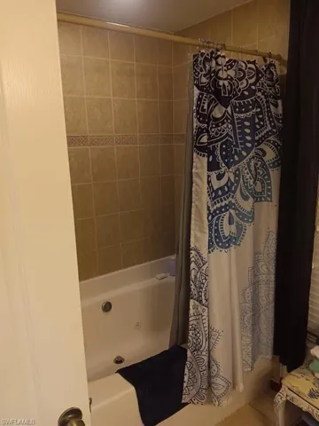 Bathroom featuring shower / tub combo with curtain
