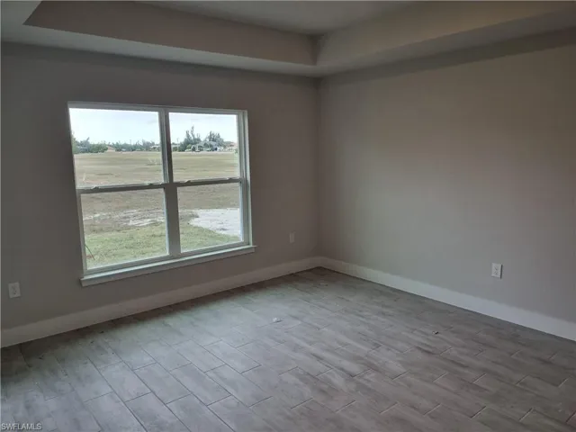 Empty room with a tray ceiling and wood tiled floors