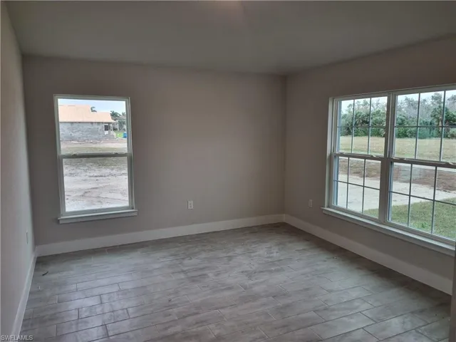 Unfurnished room featuring wood tiled floors and baseboards