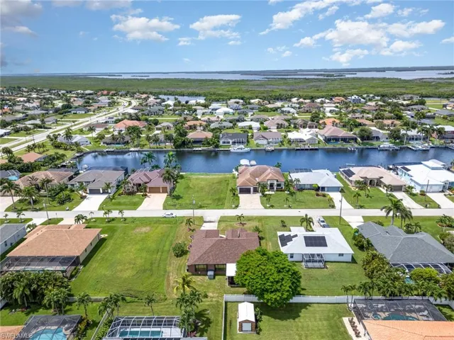 Aerial view of property's location with nearby suburban area and a nearby body of water