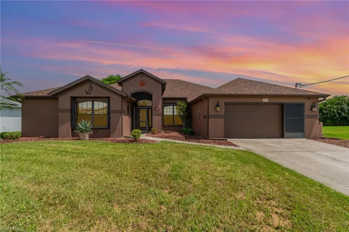 View of front of house with stucco siding, driveway, an attached garage, a front yard, and roof with shingles