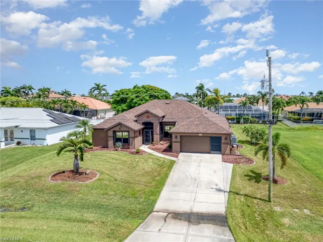 Ranch-style home with concrete driveway, stucco siding, an attached garage, and a front yard