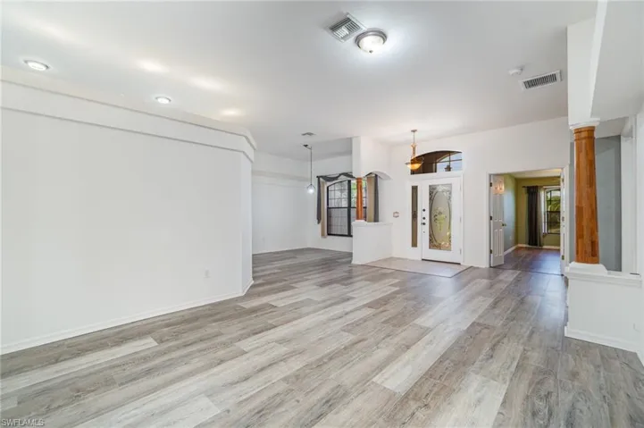 Unfurnished living room with light wood-type flooring and baseboards