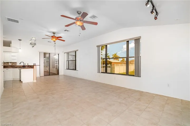 Unfurnished living room with a ceiling fan and track lighting