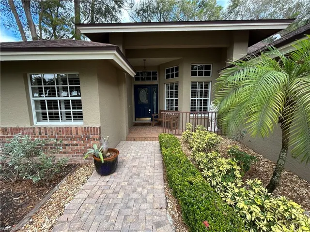 Property entrance with stucco siding and brick siding