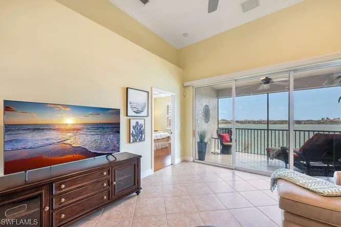 Living area with light tile patterned flooring, ceiling fan, and baseboards