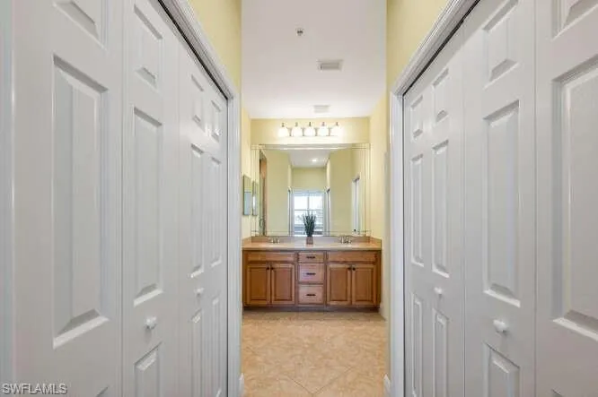 Bathroom featuring double vanity, a closet, and tile patterned floors