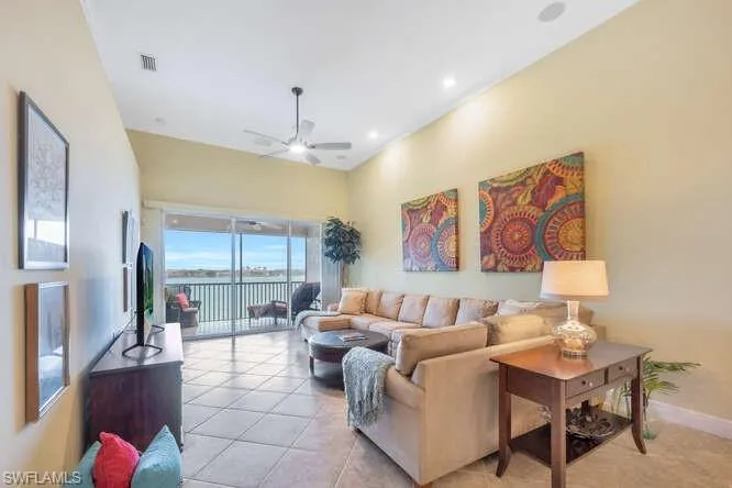 Living room with ceiling fan, light tile patterned flooring, recessed lighting, visible vents, and baseboards