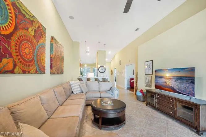 Tiled living area featuring ceiling fan and lofted ceiling