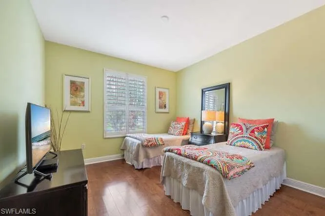 Bedroom featuring wood finished floors and baseboards