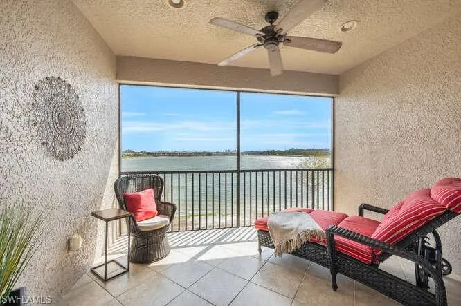 Sunroom / solarium featuring a healthy amount of sunlight, a water view, and ceiling fan
