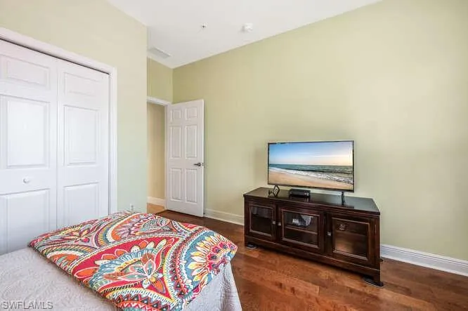 Bedroom featuring a closet, baseboards, and wood finished floors