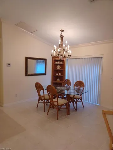 Dining space featuring crown molding, light tile patterned floors, and a chandelier