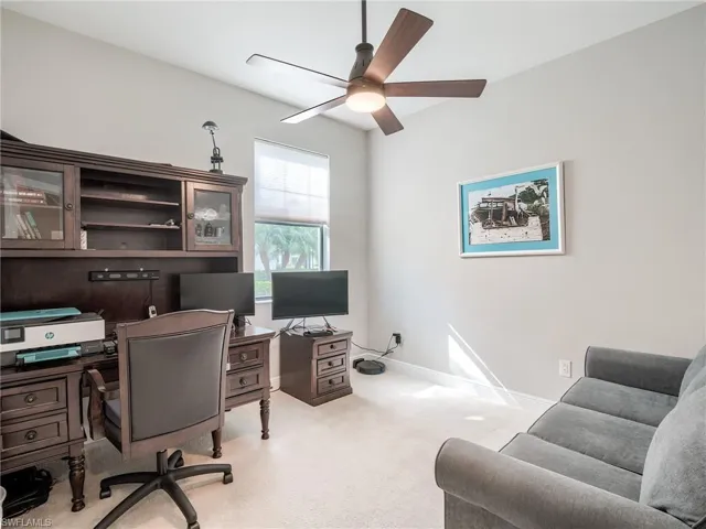 Office space with ceiling fan and light colored carpet