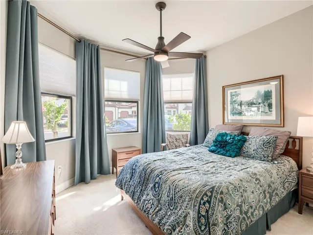 Carpeted bedroom featuring ceiling fan