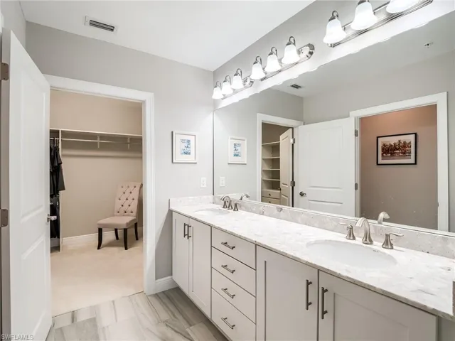 Bathroom with double vanity and tile flooring