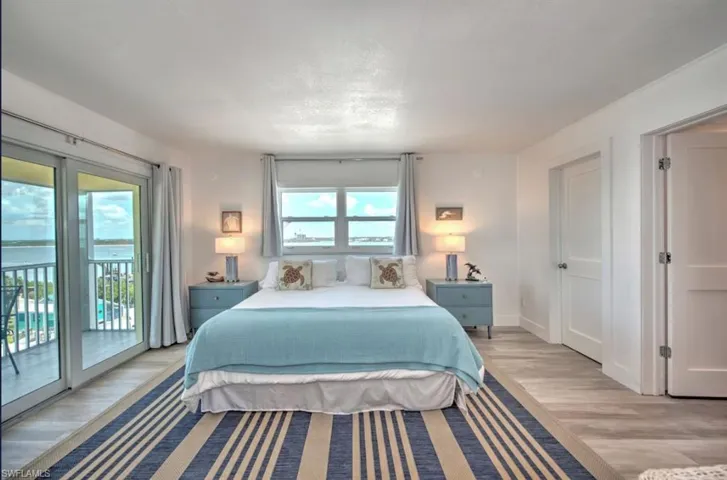 Bedroom with access to exterior and light wood-style LV floors