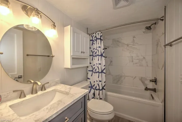 Full bathroom with shower / bath combo with shower curtain and vanity