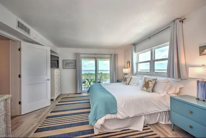 Main Bedroom with access to outside, light wood-type flooring, and multiple windows and private balcony