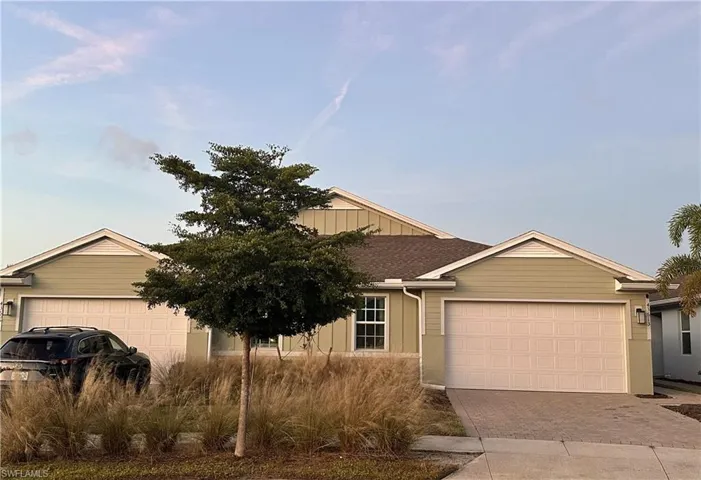 Ranch-style home with a shingled roof and driveway