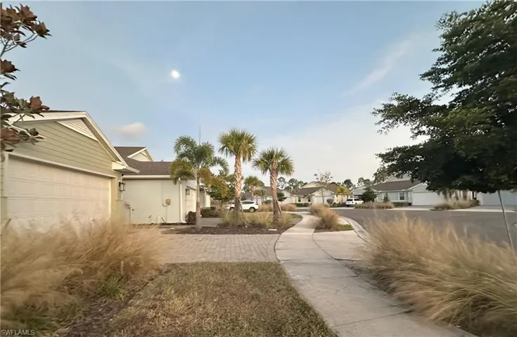 View of yard featuring a residential view, a garage, and driveway